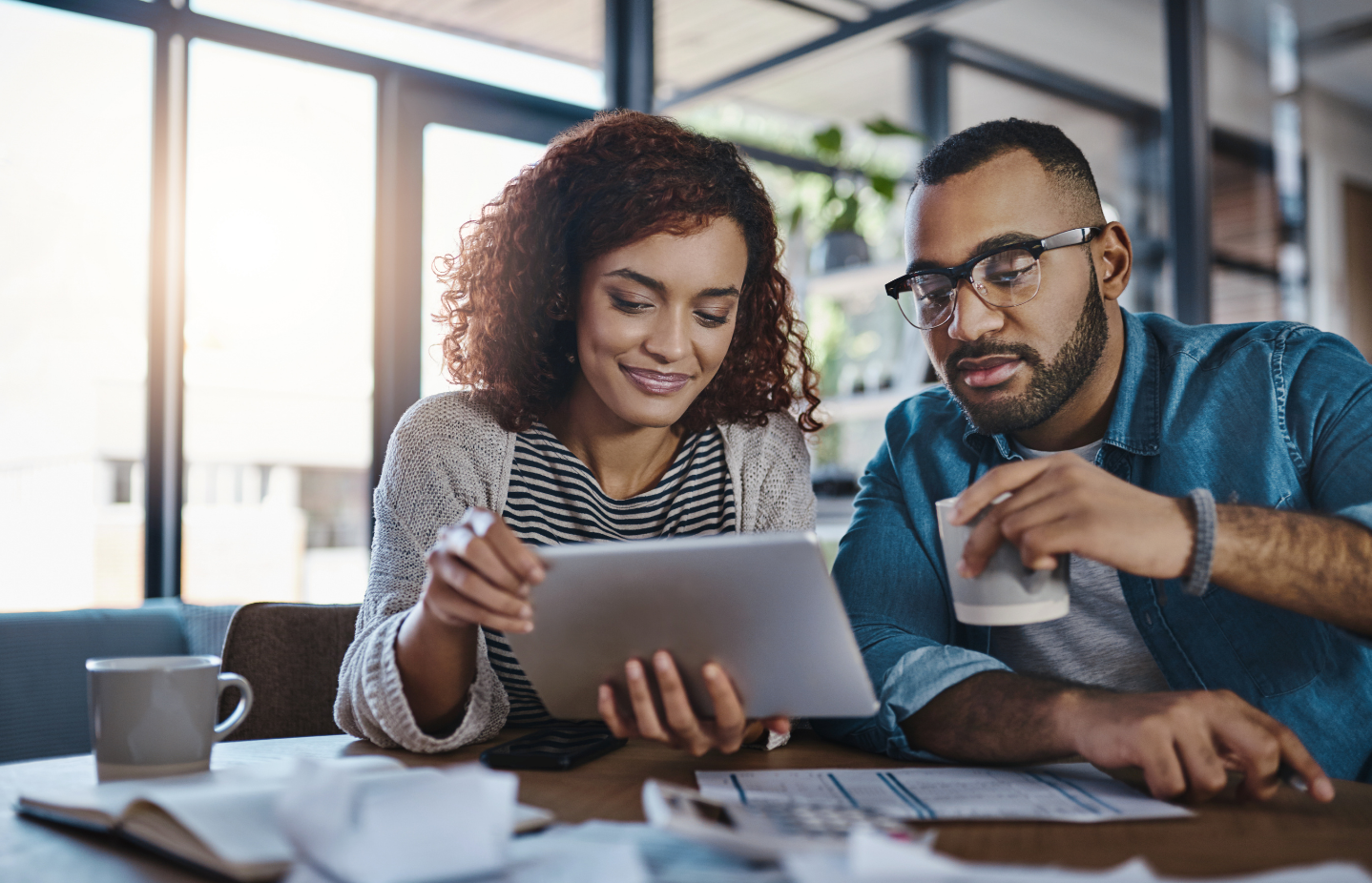 Credit Score Tips For Homebuyers Couple reviewing mortgage documents with a loan officer